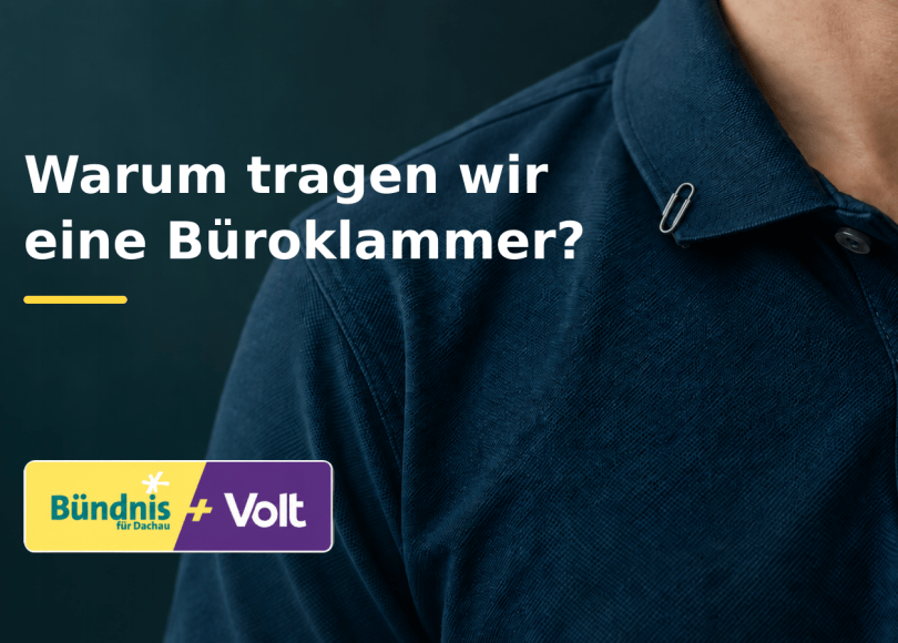 Büroklammer am Kragen eines blauen Poloshirts mit der Frage: Warum tragen wir eine Büroklammer?