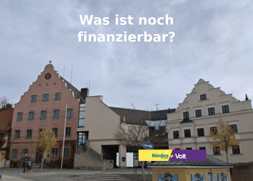 Rathaus Dachau mit der Frage „Was ist noch finanzierbar?“ und dem Logo von Bündnis für Dachau + Volt
